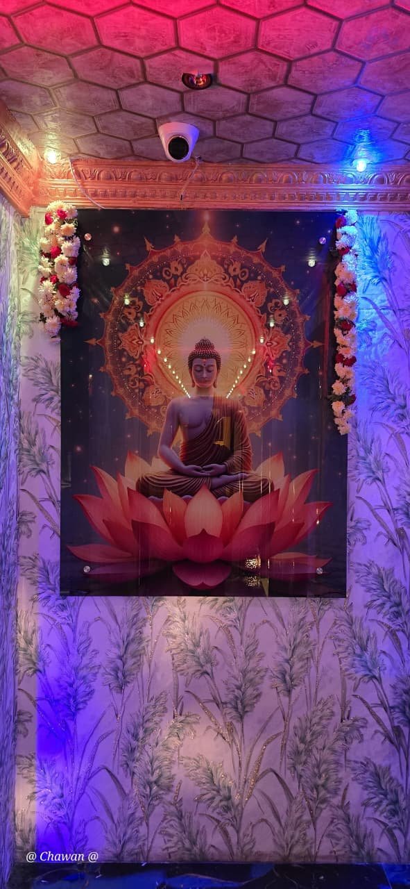 Serene Buddha artwork with flower garlands at Phoenix International Spa