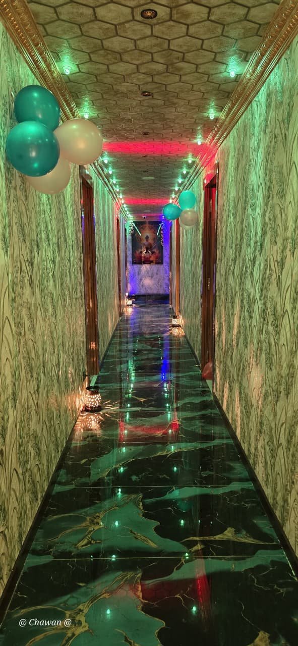 Teal-green lit corridor at Phoenix International Spa decorated with balloons