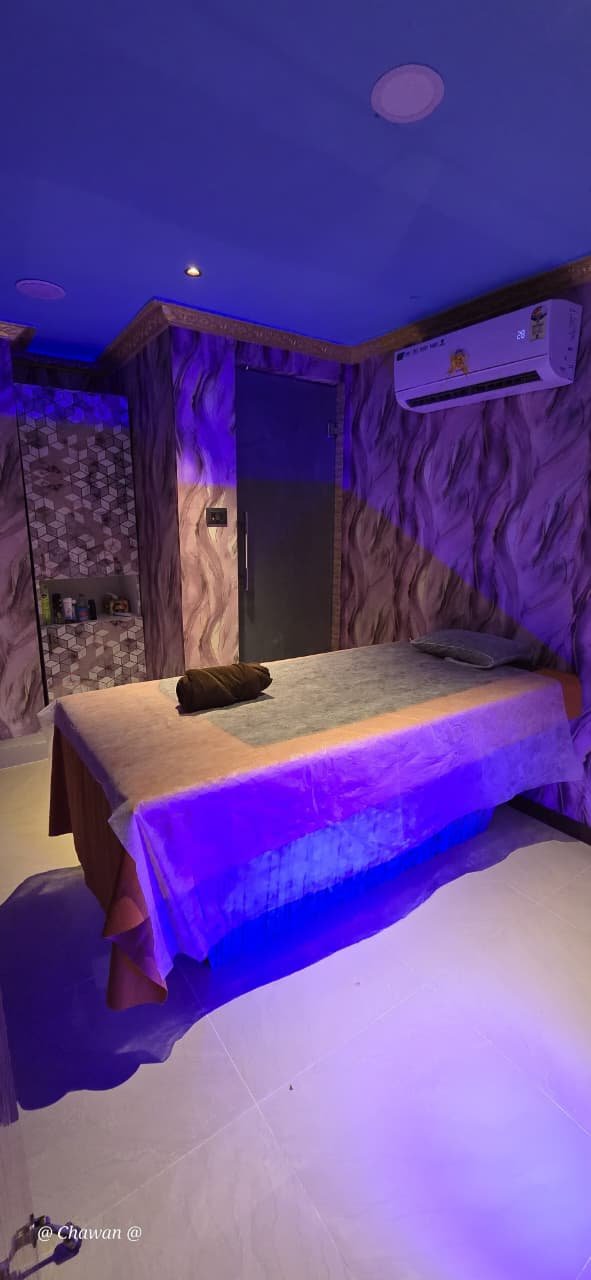 Private massage therapy room with premium bed and mood lighting at Phoenix International Spa
