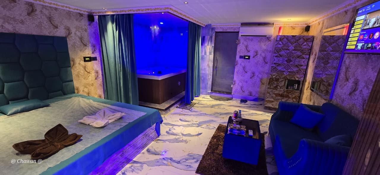 VIP suite with blue LED lighting, bed and in-room jacuzzi at Phoenix International Spa